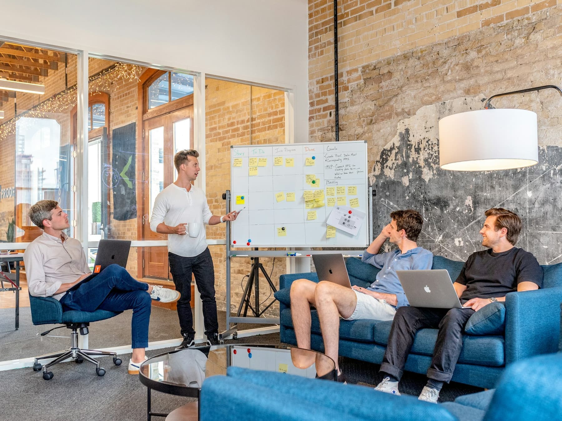 A small team in a planning session around a whiteboard in a bright office.